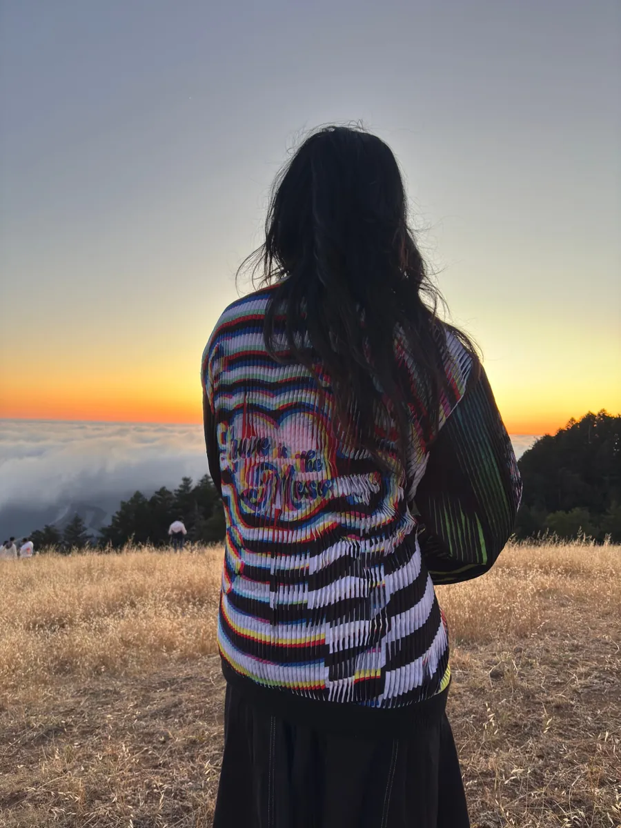 The same jacket from behind, its ribbed lenticular stripes catching the evening light.